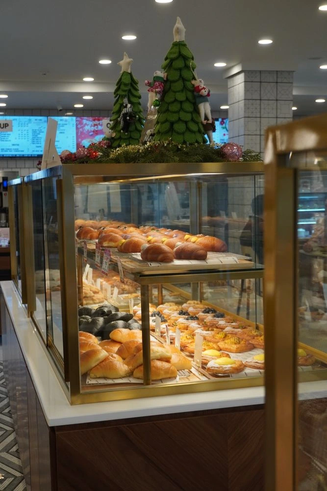 Fresh breads and pastries in a Belle Journée Bakery display case.